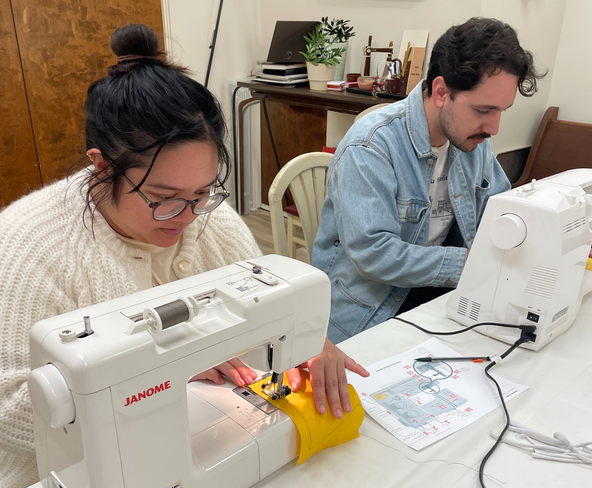 Two adults learning to sew